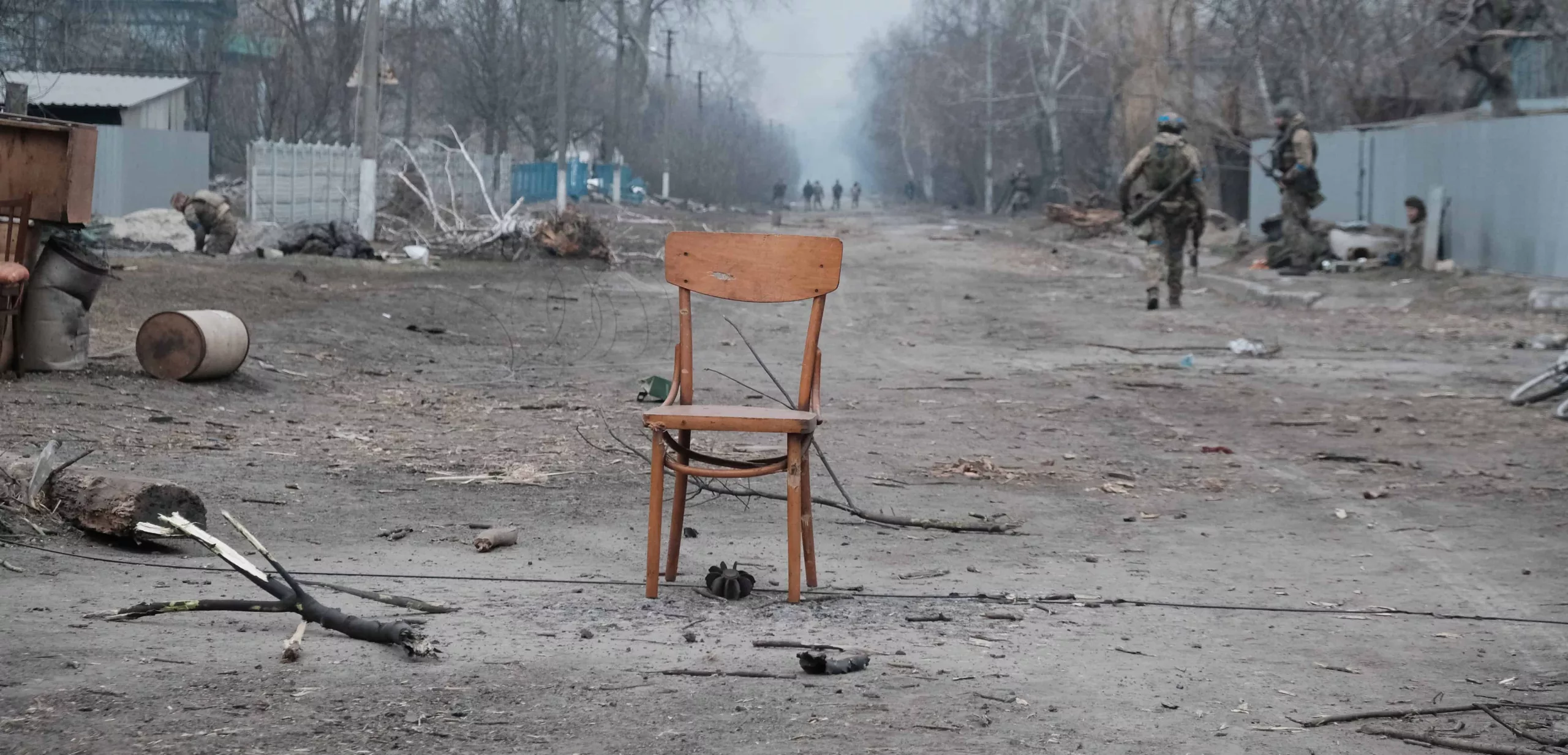 Wooden chair in shelled street Empty wooden chair in middle of shelled street