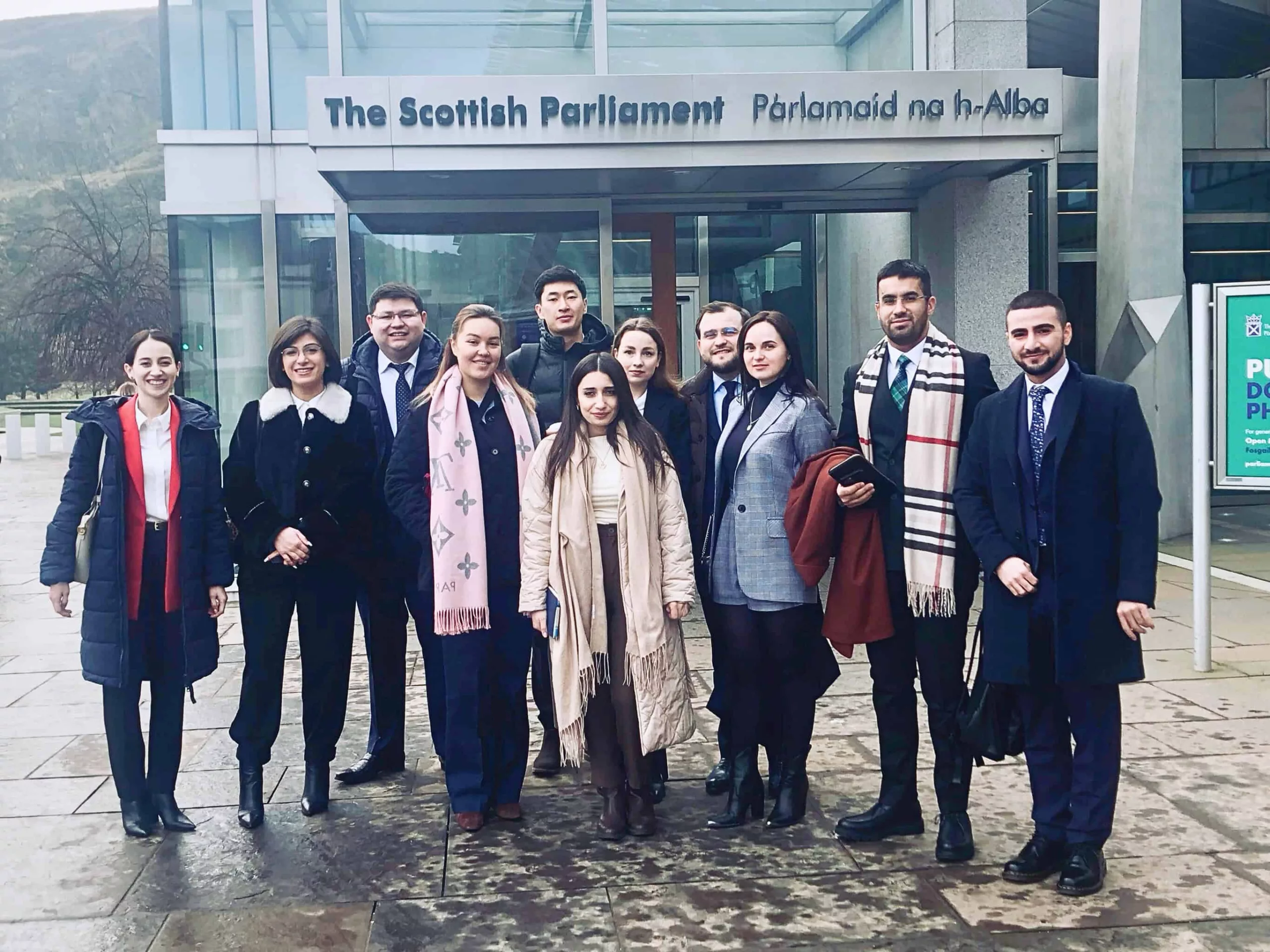 d9a3e7db-a3c2-4a13-860f-c0285b0e11ea A group of young people standing in front of the Scottish Parliament building