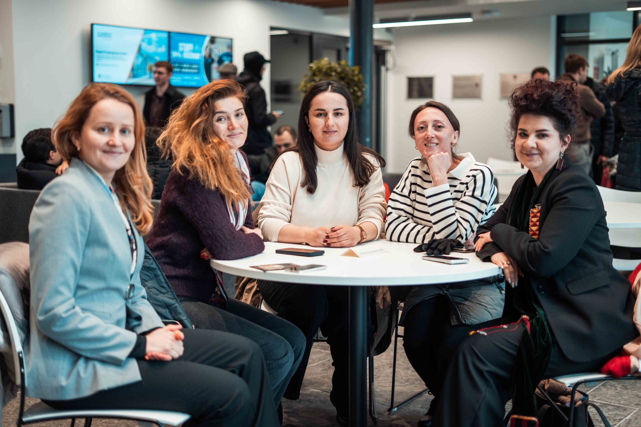 Five JST female Fellows sitting round a table