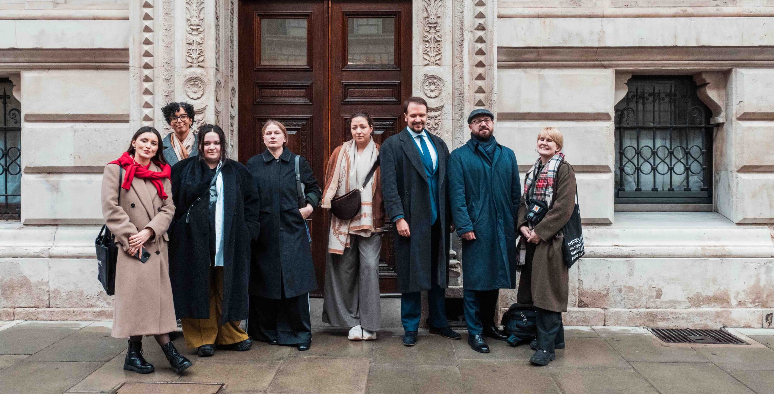 Belarus Fellows at FCDO 8 Fellows lined up against a stone building