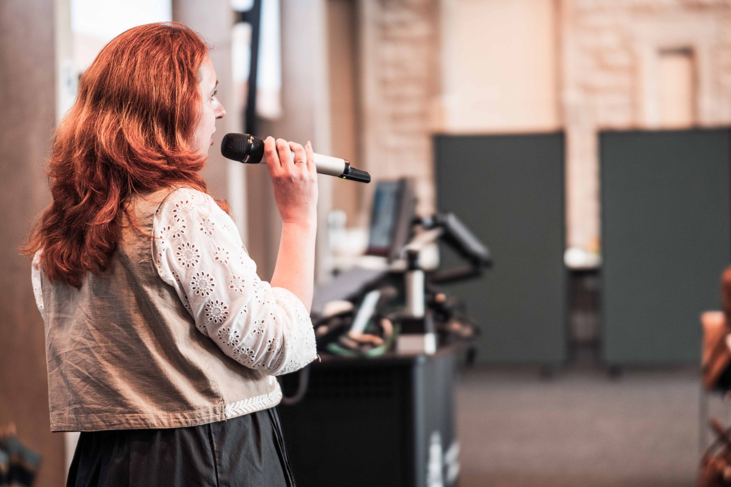 Ukrainian Women's Leadership Programme Woman with red hair speaking into a mic