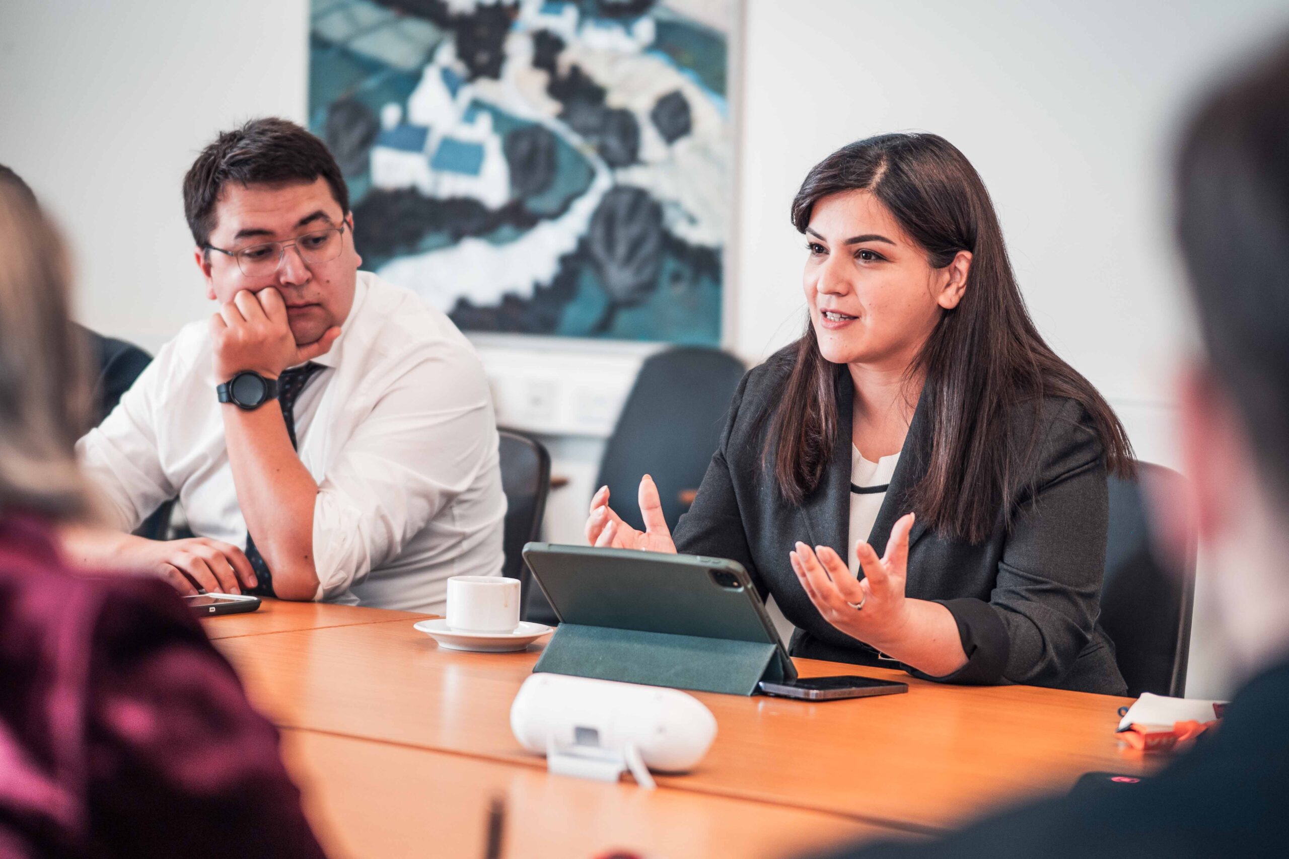 A woman speaking in a meeting around a table