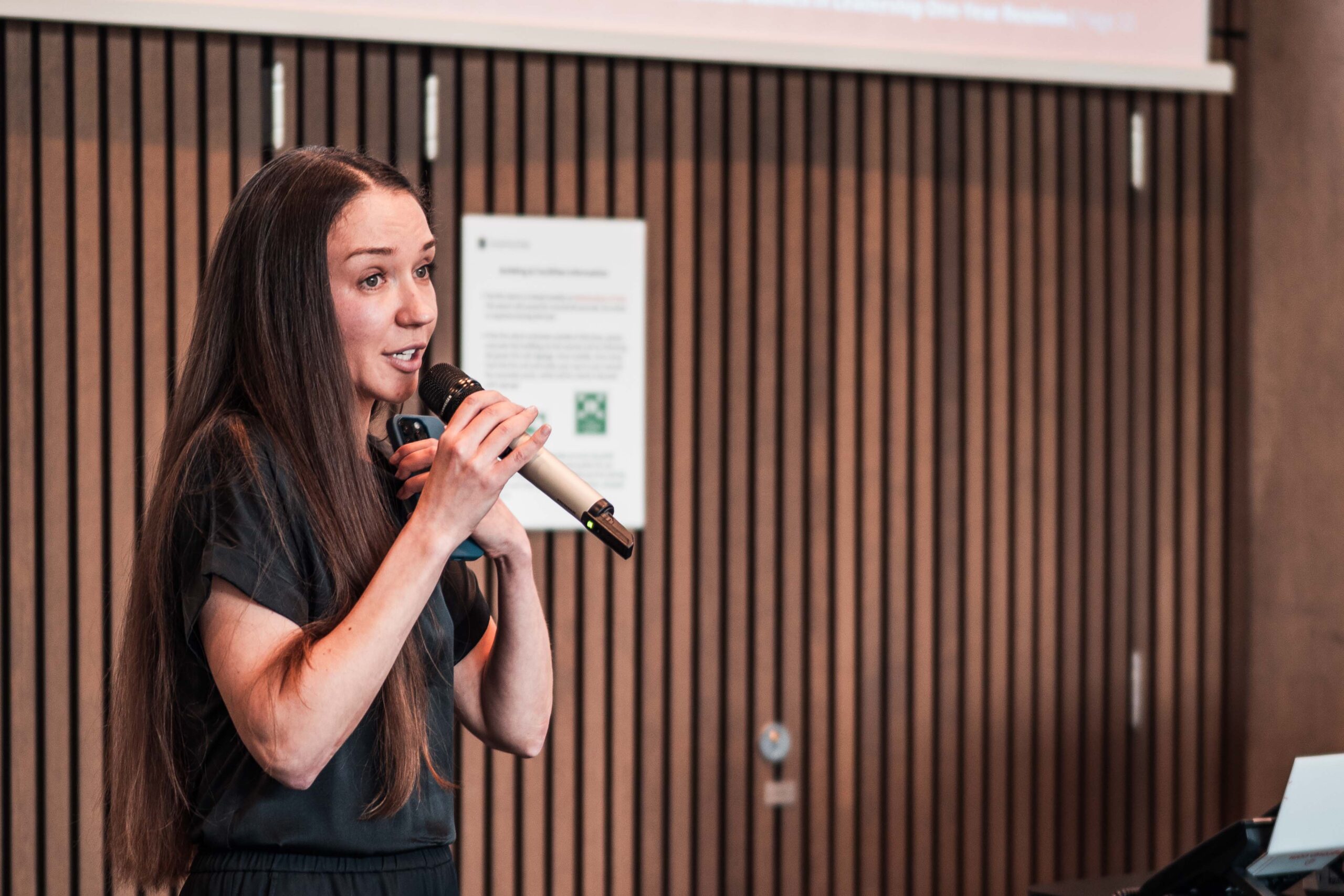 Ukrainian Women's Leadership Programme Young woman with long brown hair speaking on a mic