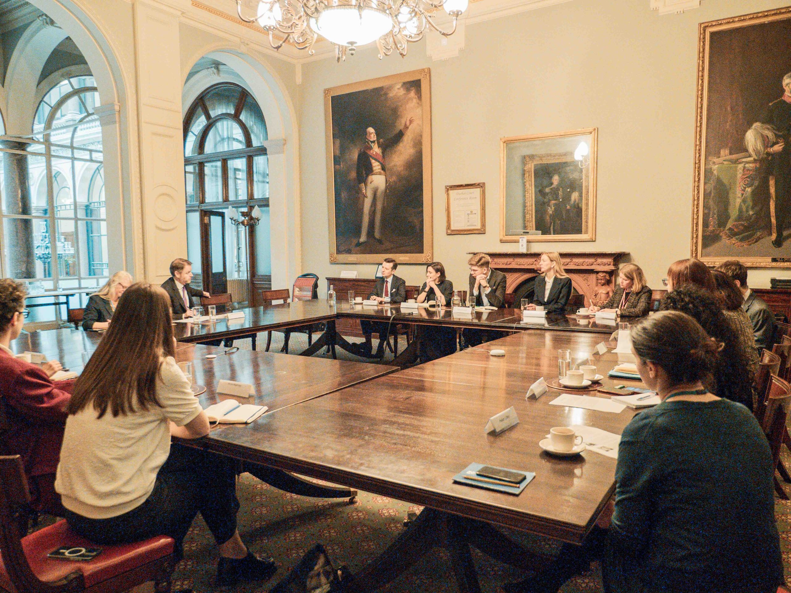 Fellows at FCDO Fellows around table in grand room at FCDO