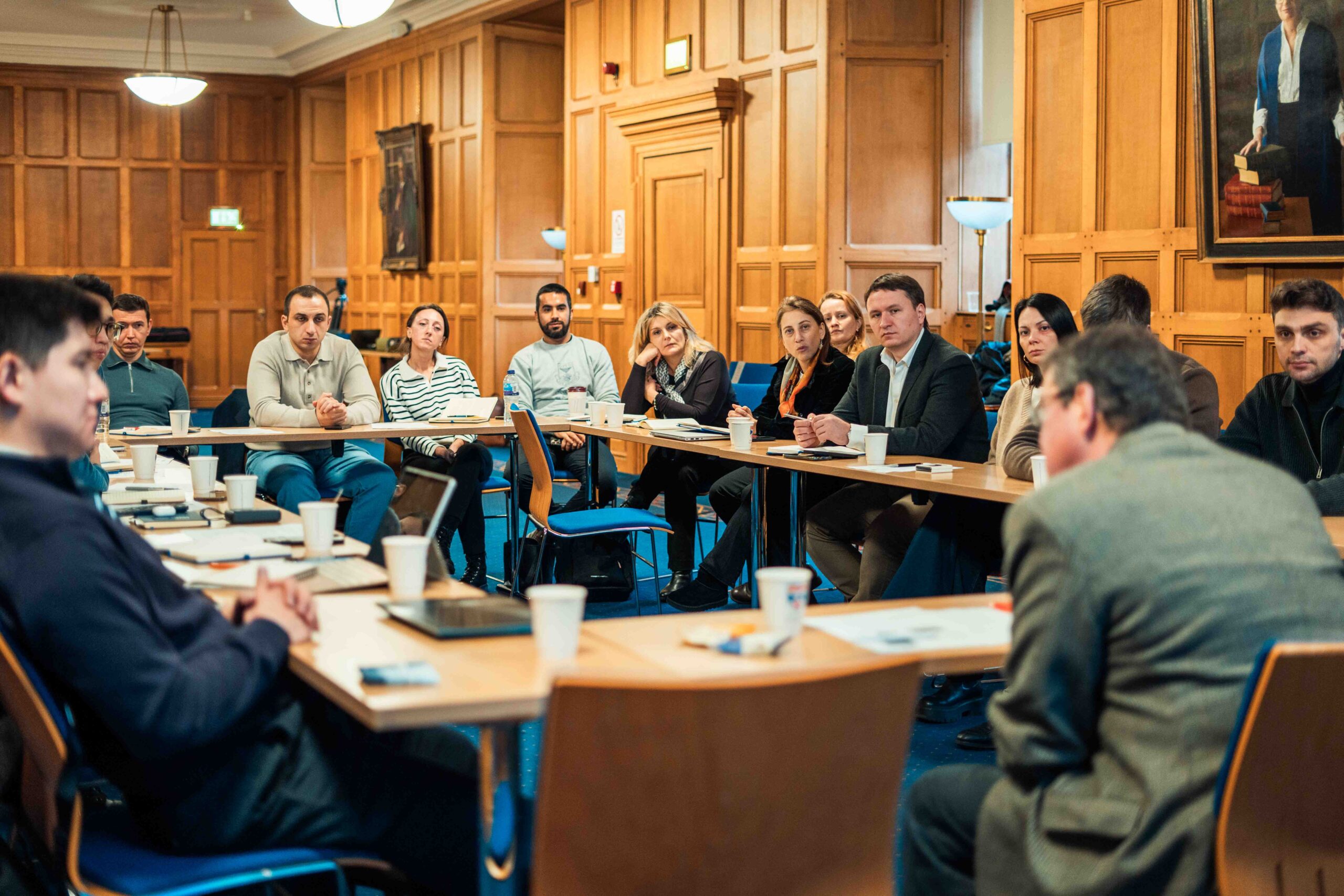 A large group of people sitting around a table talking