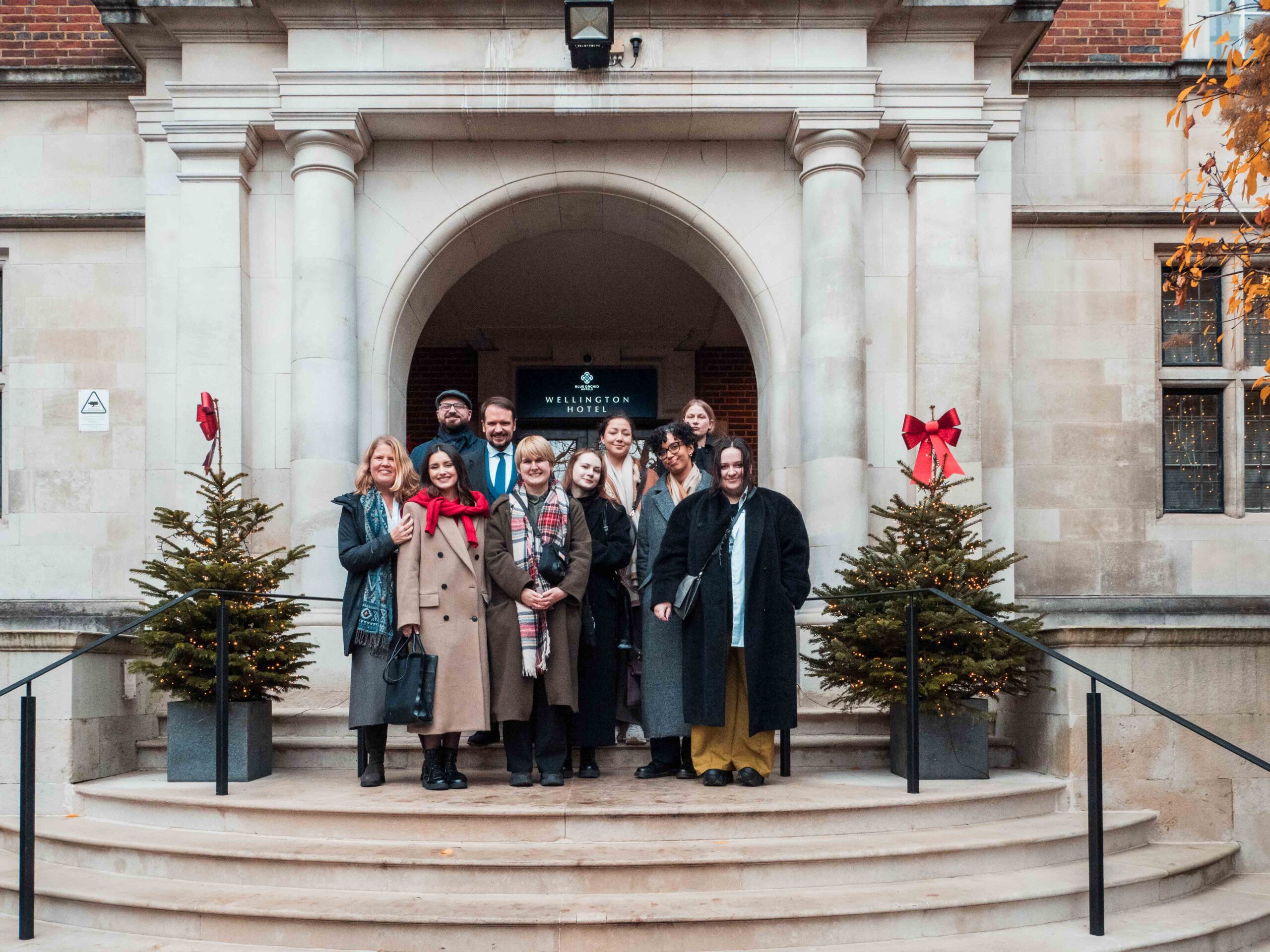 Fellows outside the Wellington A group of Fellows on steps outside hotel with small christmas trees at the side