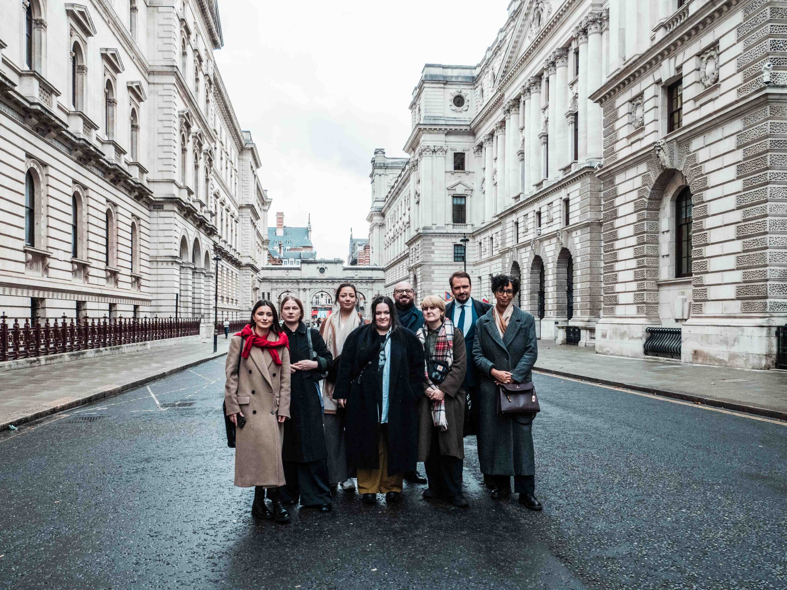 A group of Fellows standing outside the grand, stone-build FCDO building