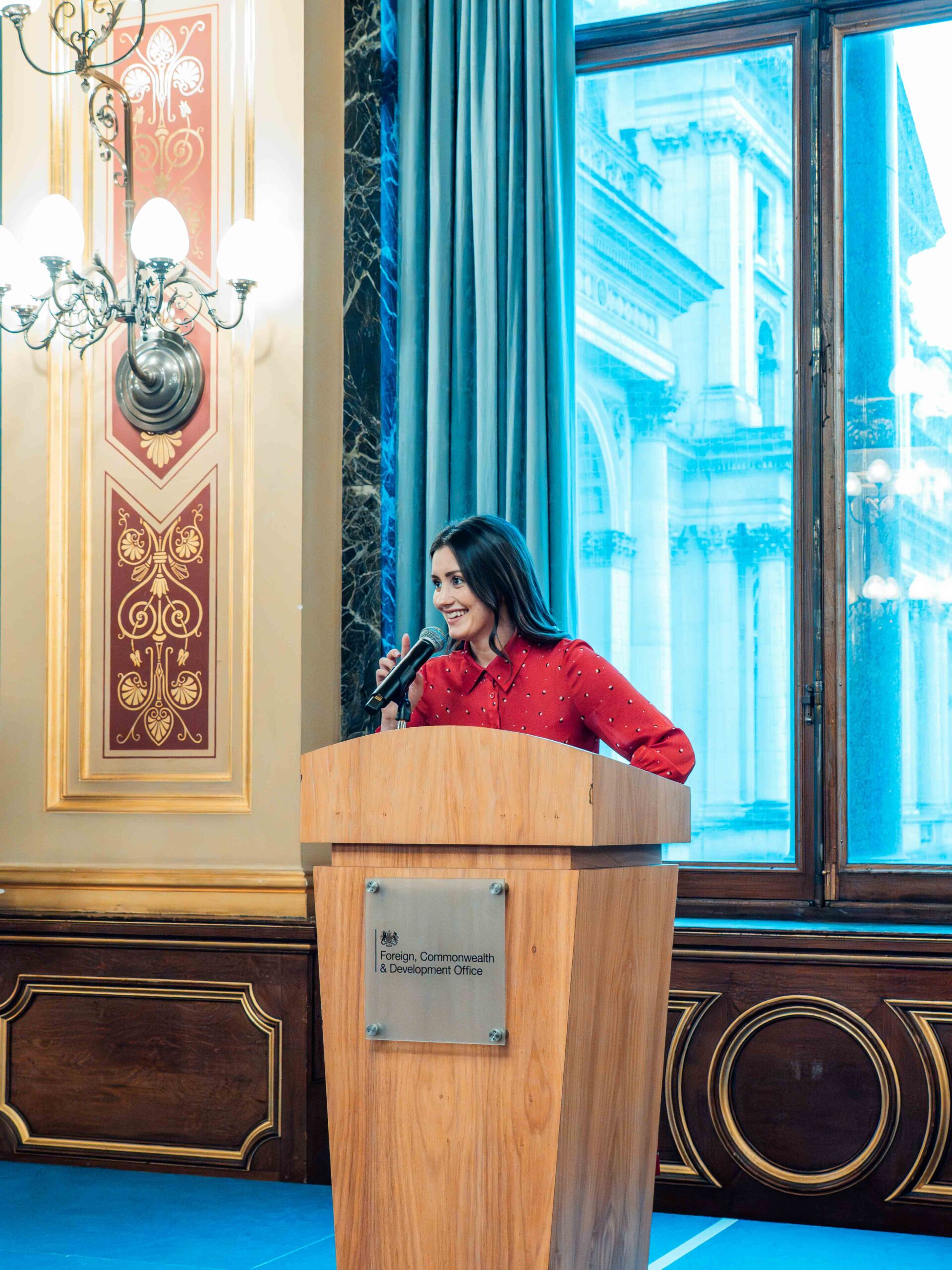 Fellow at lectern Woman in red dress standing at a lectern