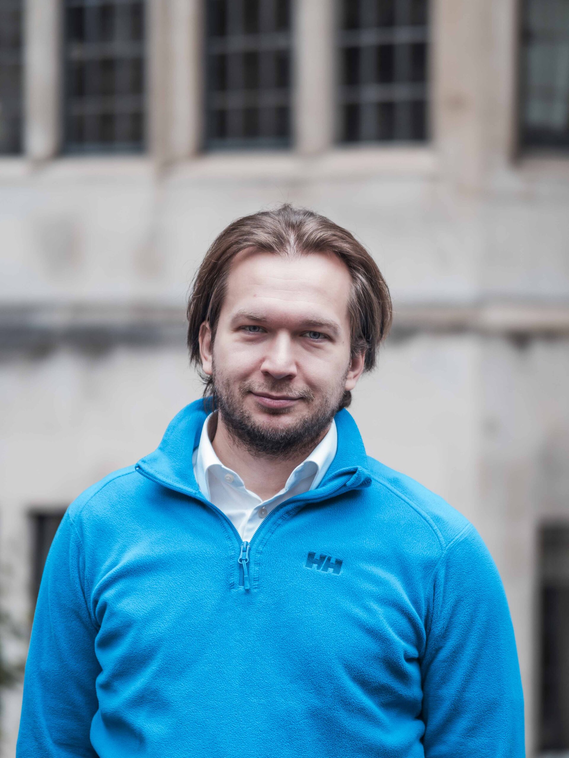 Ivan Belarus Man in blue sweater standing in front of a stone building