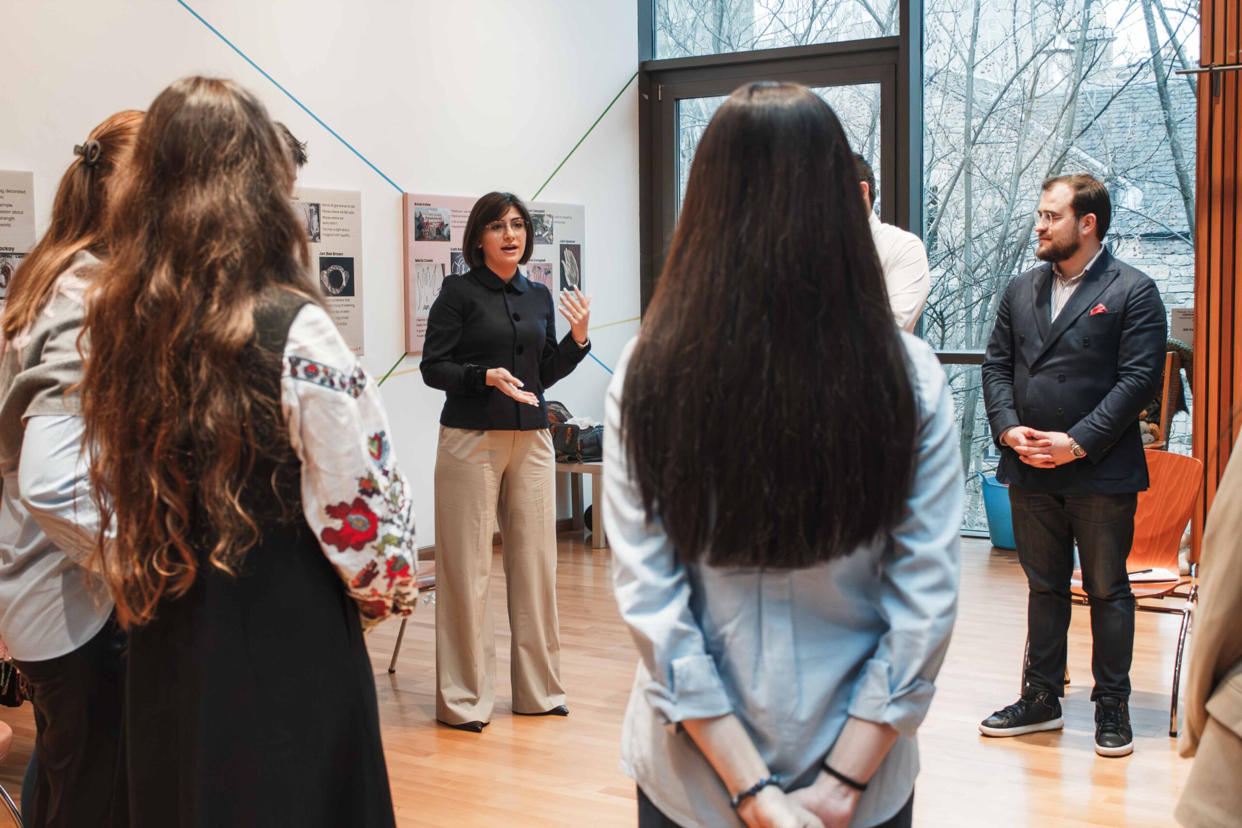 A woman presenting in a group of people standing in a circle
